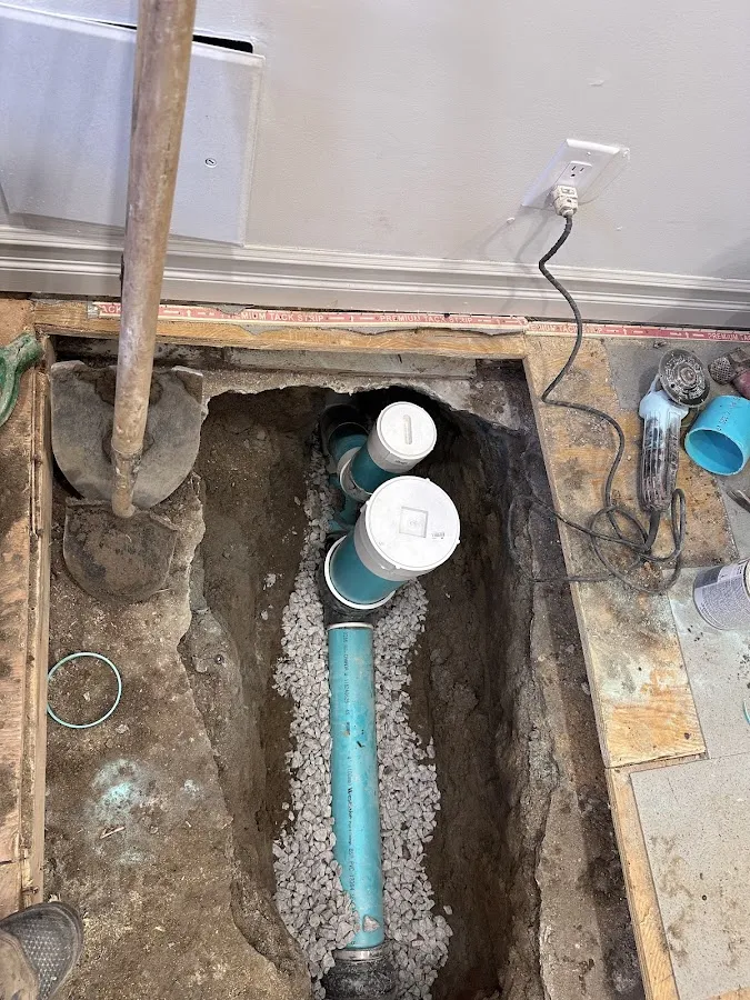 New blue PVC sewer lateral pipe with connectors installed in trench with gravel base
