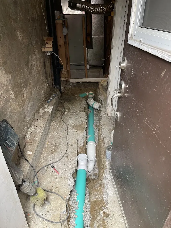 Gray aggregate and foundation drainage system installed in basement floor trench